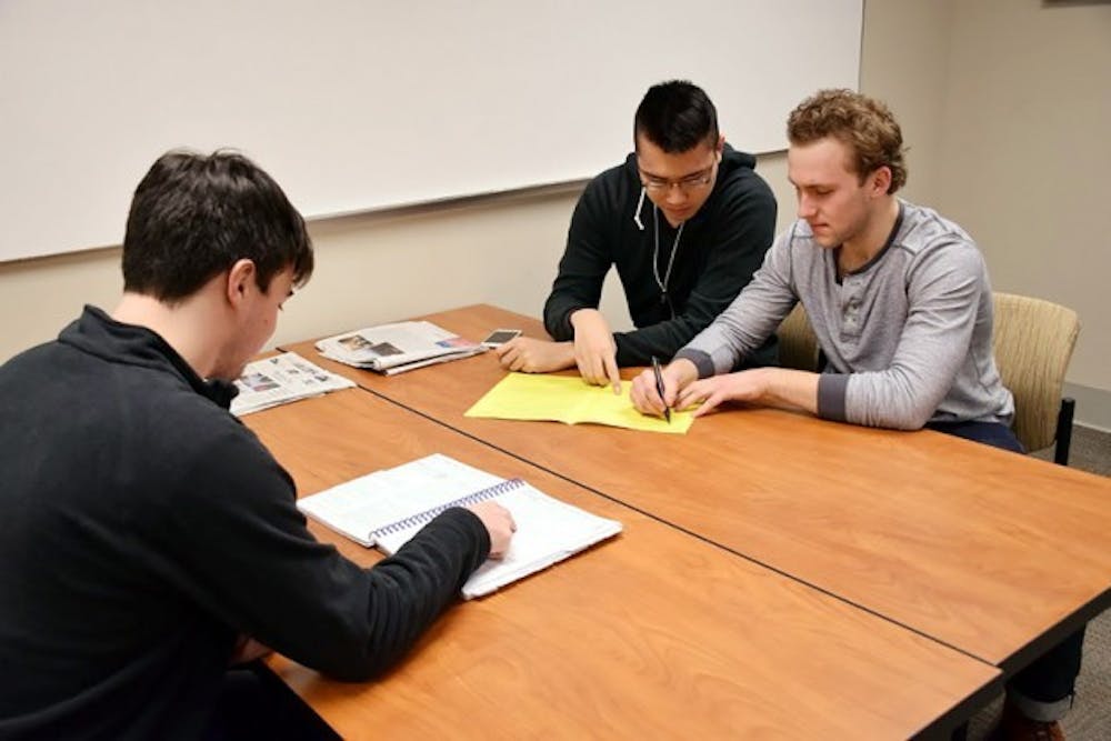 Senior accounting majors (left to right) Andrew Robertson, Andrew Leung and Spencer Gates look over paperwork. The three are part of UB&rsquo;s VITA program, which provides free tax services to the local community.&nbsp;Angela Barca, The Spectrum