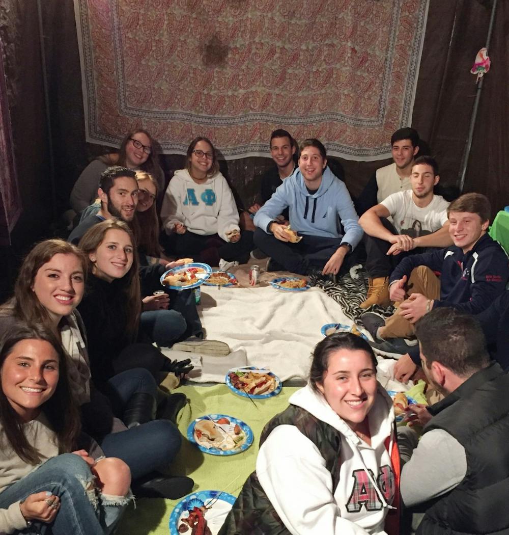 <p>UB students hang out and eat food in the Sukkah for the first meeting of Aish Buffalo, a new Jewish organization on campus. </p>