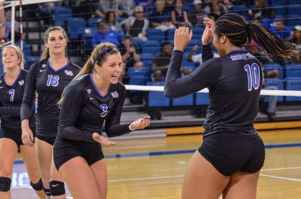<p>Senior Marissa Prinzbach (left)&nbsp;and senior Akelia Lain (right) celebrate a point from earlier in the season. The Bulls clinched the No. 7 seed in the MAC Tournament, their second berth in as many years.</p>