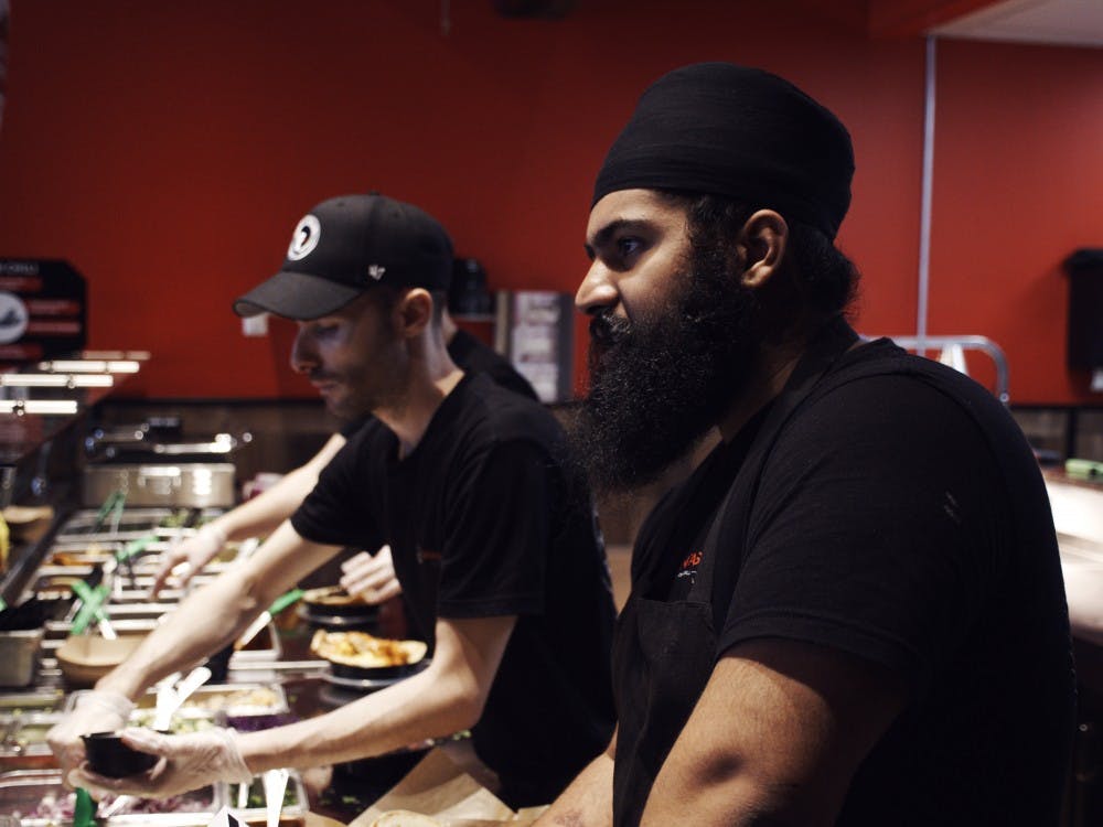 <p>Naan-Tastic workers serving customers their unconventional Indian cuisine. The novel restaurant, which opened its doors on Friday, is owned and operated by UB alum, Aman Singh, and his brother, Ajay Singh.</p>