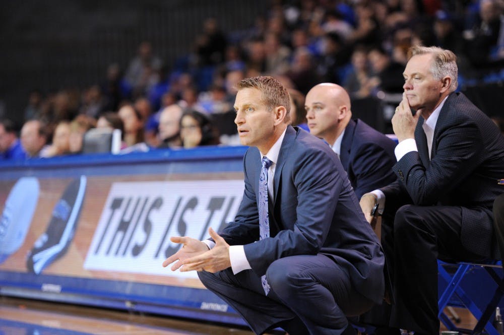 <p>Men's basketball head coach Nate Oats (center) coaches Buffalo from the sideline during an exhibition game against Daemen last week. Oats enters his first season as a Division-I head coach Friday after studying the game for as a coach for 18 years.&nbsp;</p>