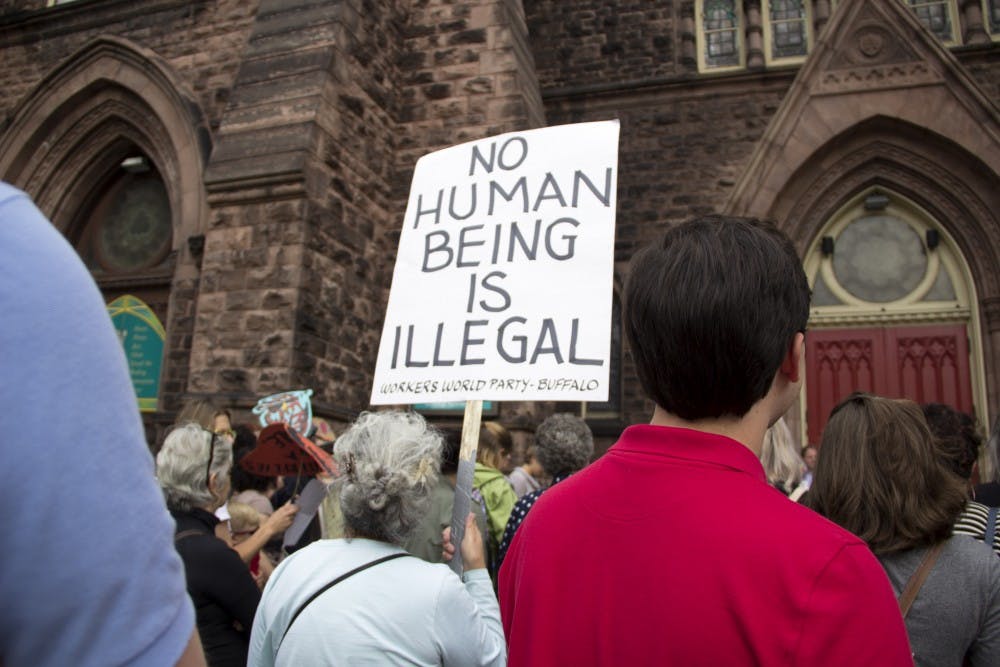 <p>A woman at the "March to Defend DACA and Divest from Deportation" rally holds a sign that reads, "no human being is illegal."&nbsp;</p>