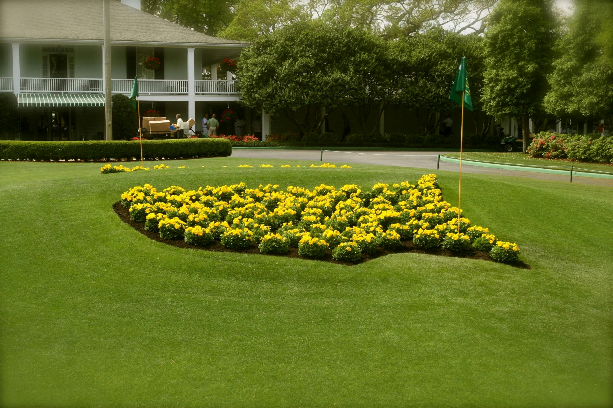 The logo for the Masters Tournament made of flowers, in front of the clubhouse of the Augusta National Golf Club.