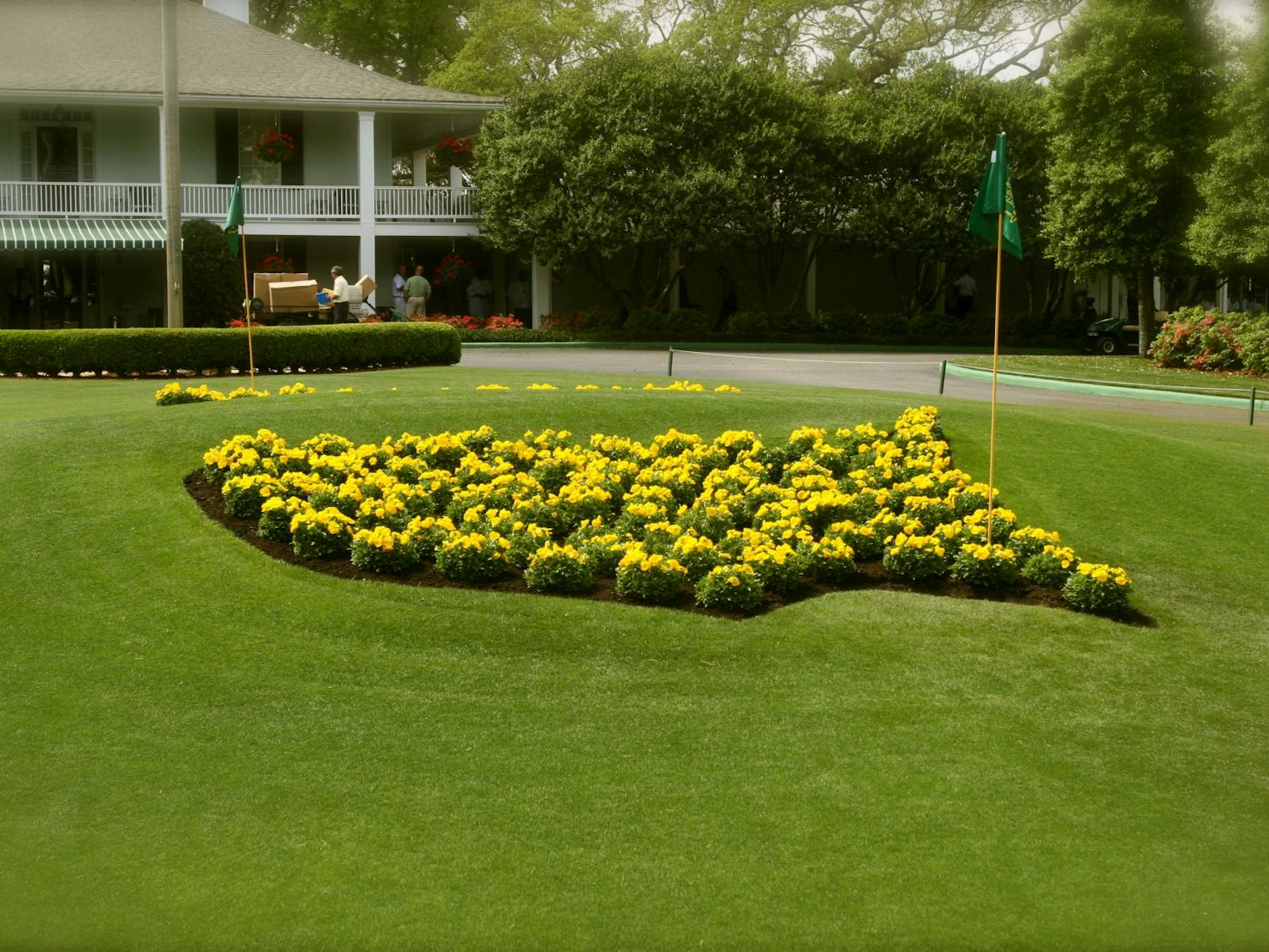 The logo for the Masters Tournament made of flowers, in front of the clubhouse of the Augusta National Golf Club.