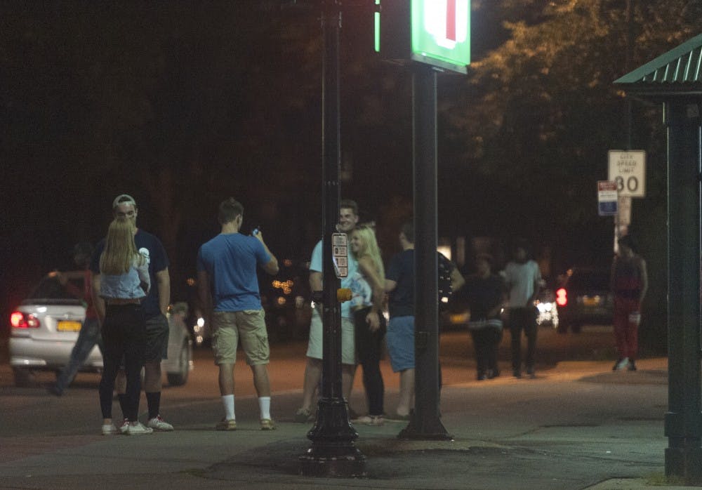 <p>Students stand on the corner of Main Street and Winspear Avenue in the University Heights last month. UPD expects to see an increase in the numbers of students in the Heights Halloween weekend. </p>