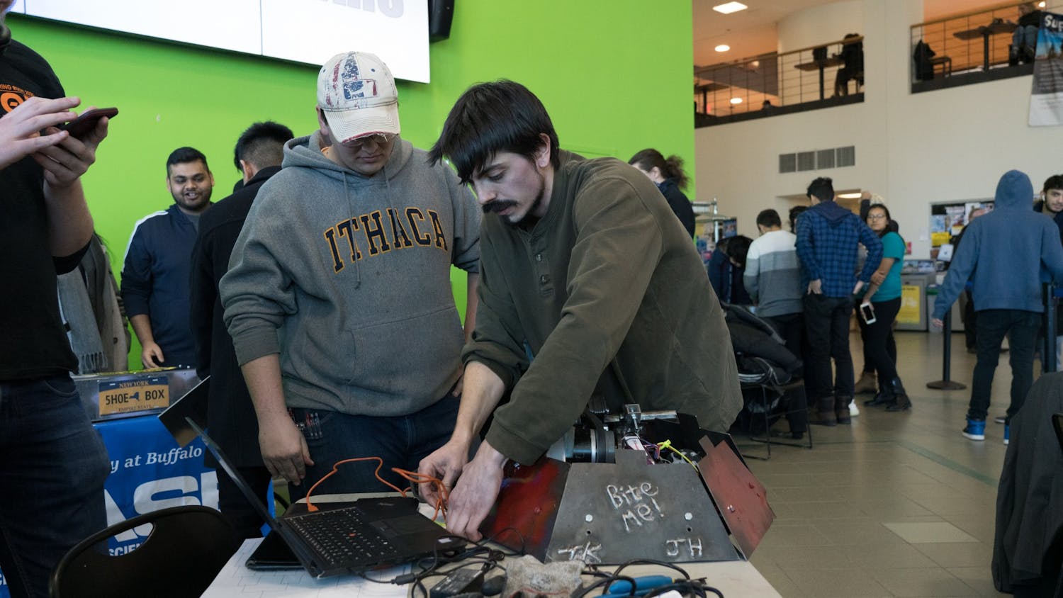 Industrial and systems engineering major Josh Hulburt (left)and mechanical engineering major Troy Kilian make repairs to their robot after winning in the arena during the previous round.
