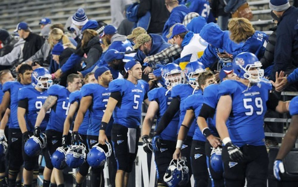 The football team celebrates with fans after its 55-24 victory over Akron on Nov. 11. The Bulls will play the day after Thanksgiving on the road for the first time since 2010. Yusong Chi, The Spectrum