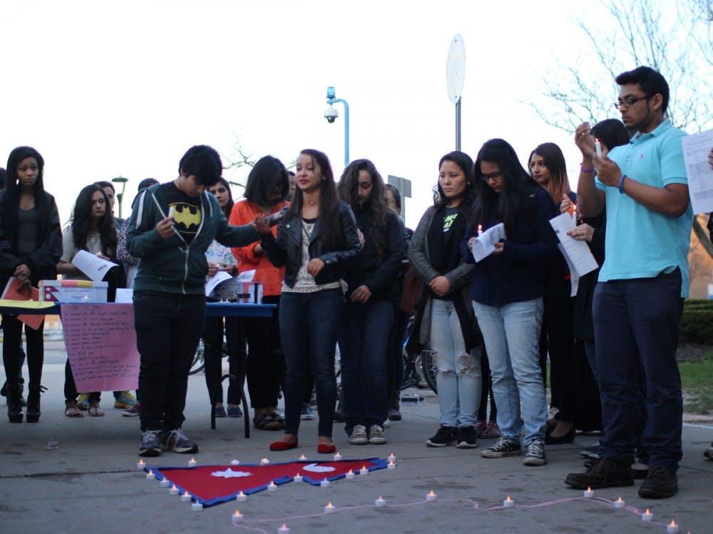 <p>Sofiya Karki (center), president of Bangladesh Student Association (BSA), holds back tears as she speaks of her friends in Nepal who are terrified to step into their own home in fear it may collapse. The BSA held a candlelight vigil attended by approximately 150 students for the victims of the Nepal earthquake that occurred on Saturday.</p>