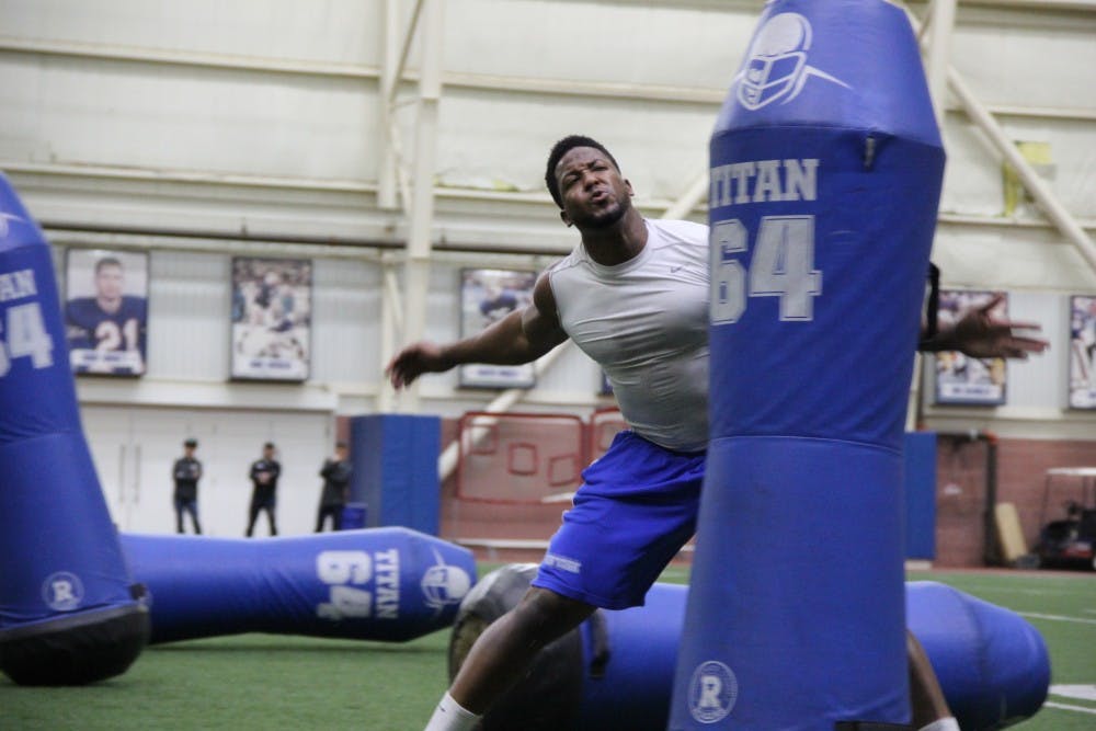 Tedroy Lynch, a graduated Bull, competes in a defensive drill, taking down tackle dummies.
