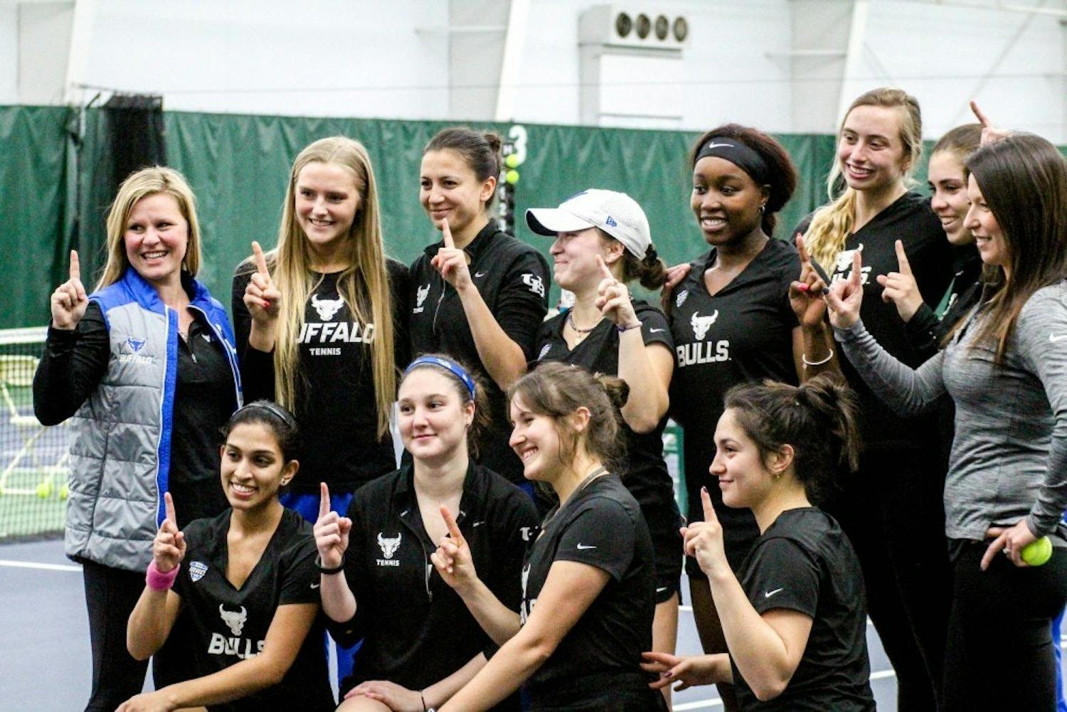 The Bulls pose to celebrate their win. The women’s tennis team opened its 2019 spring season with two dominating performances.