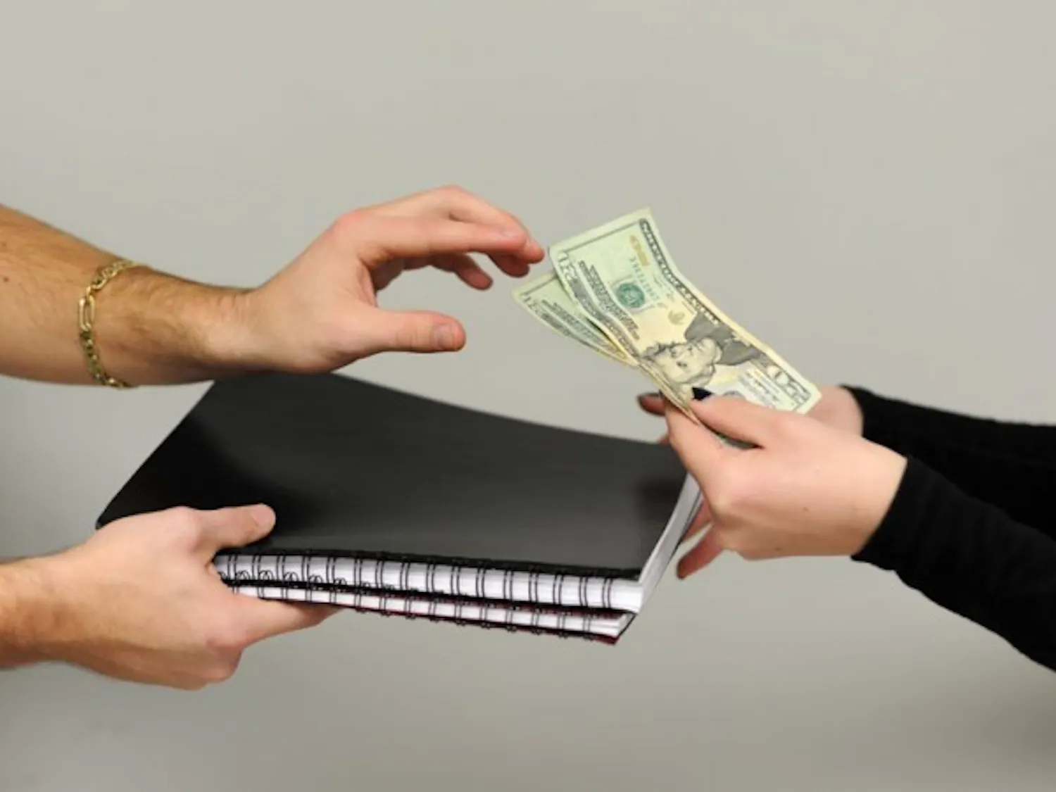 Photo Illustration: An unknown number of professors at UB write and assign their own textbooks to students. These professors go completely unregulated and students wonder if its ethical. Dietrich Kuhlmann, one of the numerous professors who do this, charges students $40 in cash and they receive two of the three texts (shown here) for STA 119 up-front and the third during the semester.
Yusong Shi, The Spectrum