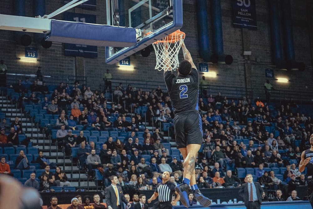 <p>Senior guard Antwain Johnson goes in for the dunk.</p>