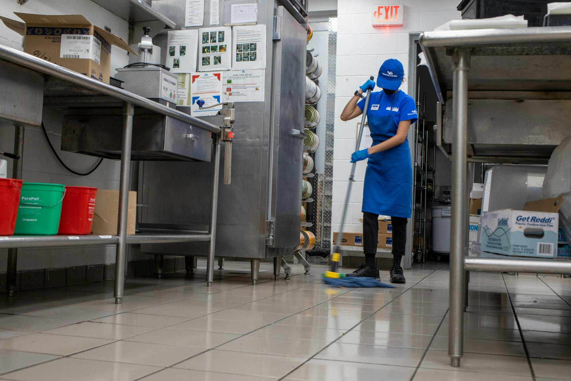 A CDS employee mops the floor in one of UB’s on-campus kitchens.&nbsp;