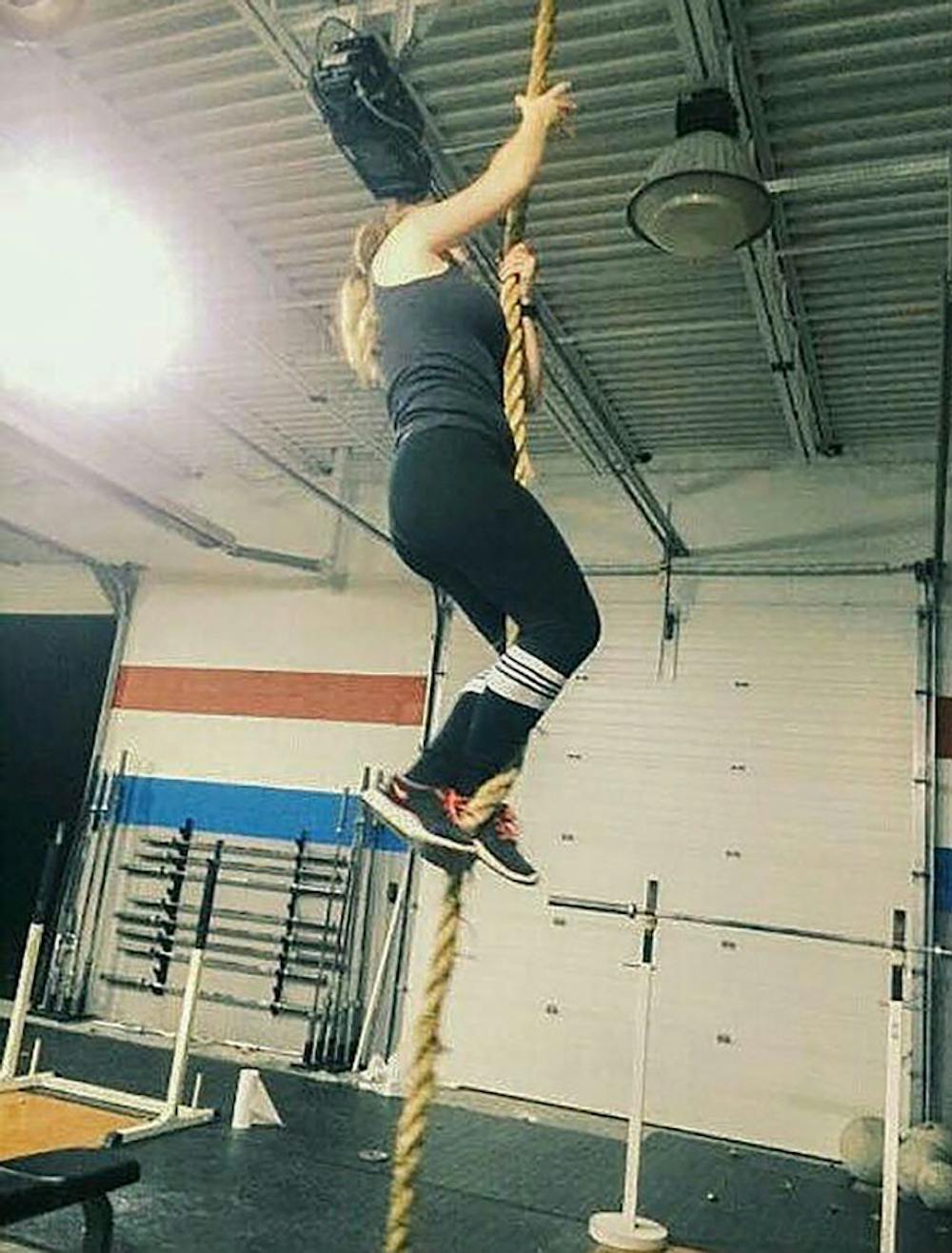 <p>Morgan Dressler climbs up a rope as a part of her CrossFit regimen.&nbsp;Dressler first started doing CrossFit more than a year ago and since then feels as if her life has changed for the better.</p>