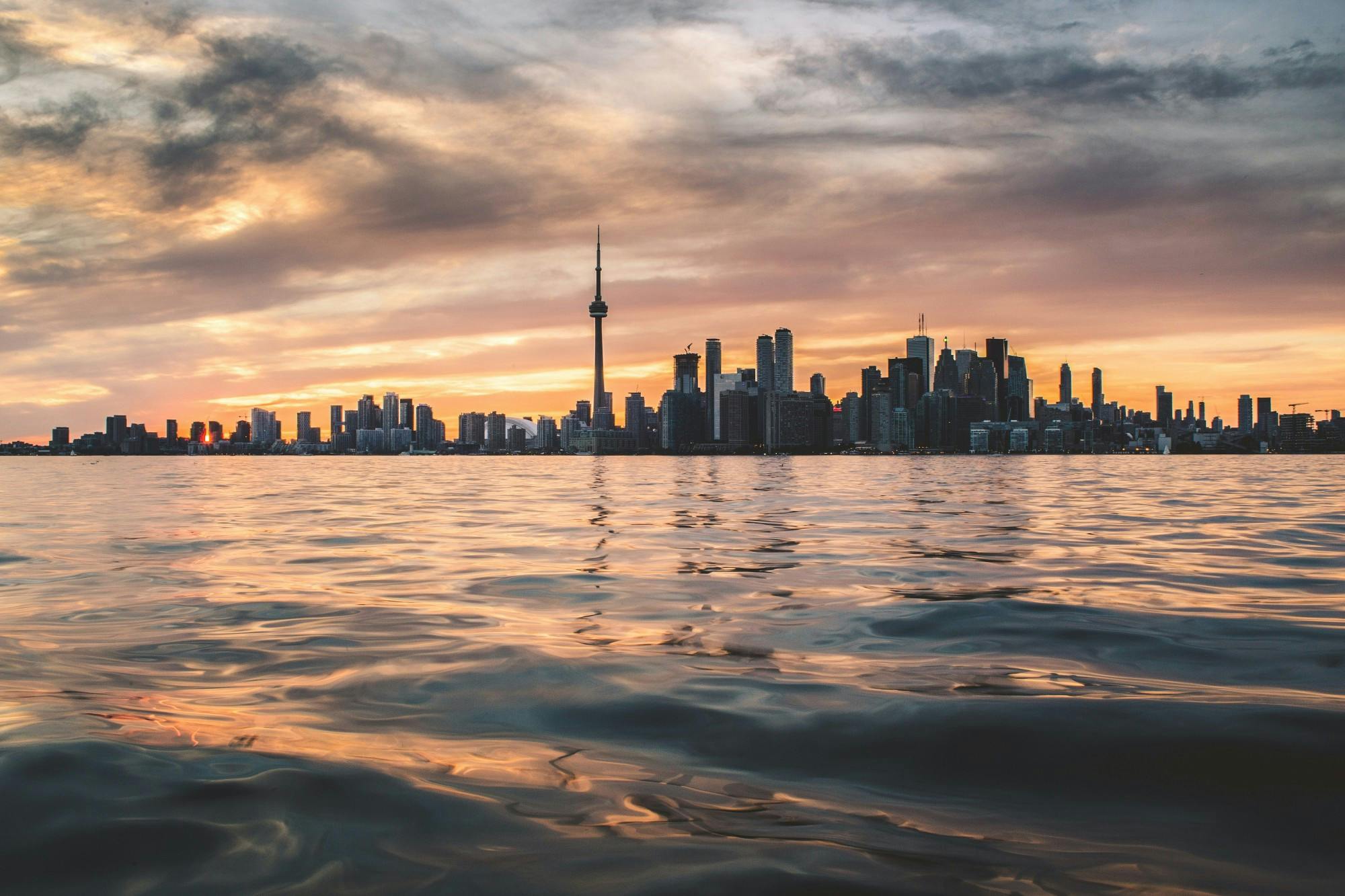 Toronto looms large over a body of water. Students should go to Canada with “literal strangers,” writes Reilly Mullen.