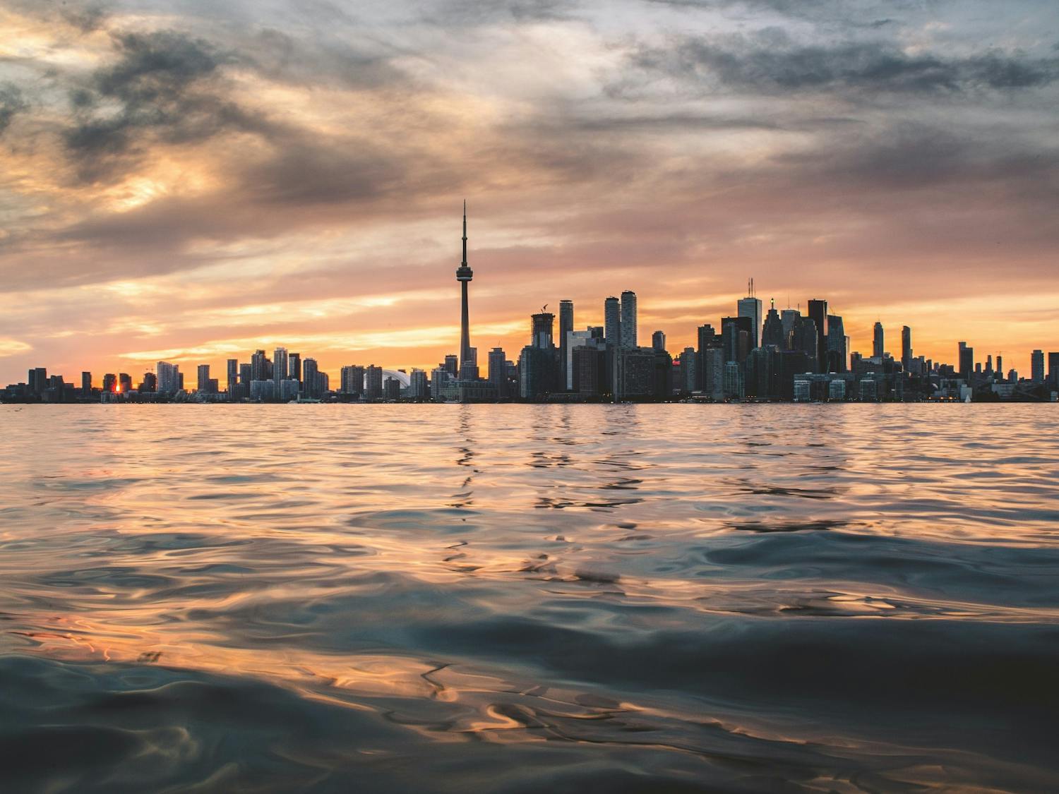 Toronto looms large over a body of water. Students should go to Canada with “literal strangers,” writes Reilly Mullen.
