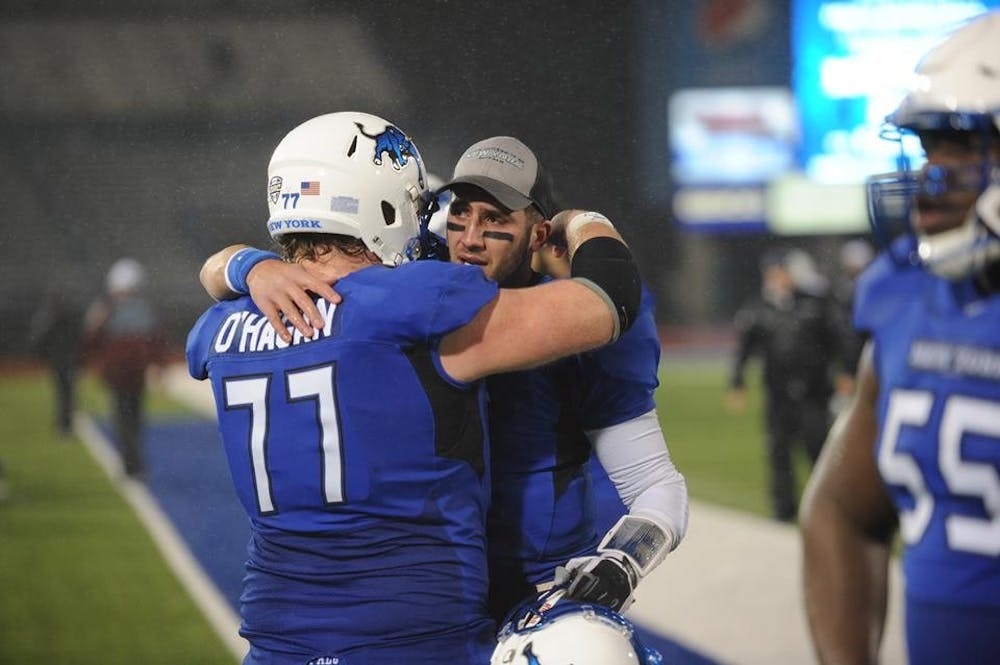 <p>Senior quarterback&nbsp;Joe Licata hugs freshman center James O'Hagan after a tough, season-ending 31-26 loss to Massachusetts at UB Stadium Friday. It was the final game of Licata's UB&nbsp;career.&nbsp;</p>