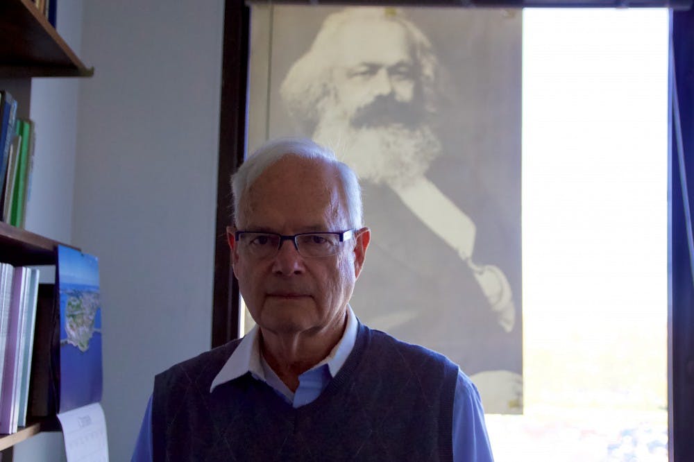 <p>Paul Zarembka sits at his desk in his office in Fronczak Hall. Zarembka has written on insider trading concerning 9/11 and has worked for multiple economic journals.&nbsp;</p>