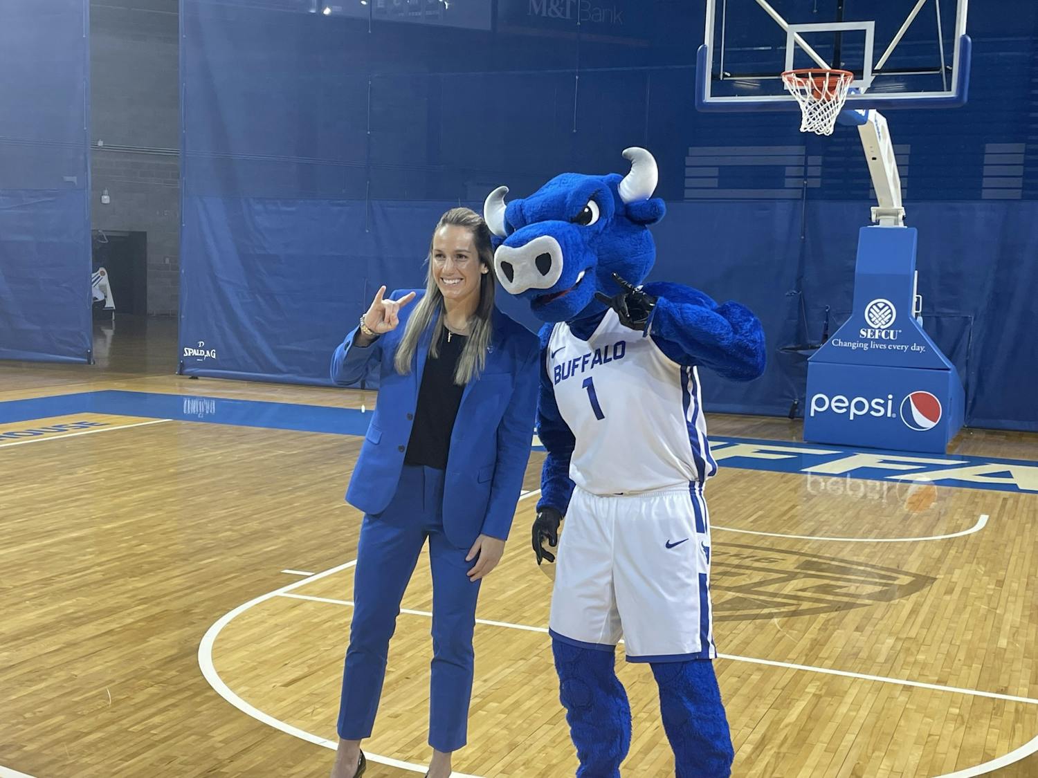 New women’s basketball head coach Becky Burke poses for a photo with Victor E. Bull at her introductory press conference at Alumni Arena Friday.