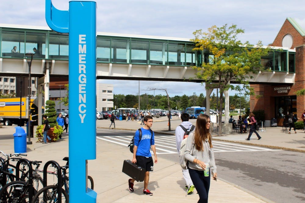 <p>Students pass by an emergency blue light located outside the Student Union. Many students feel mostly safe on campus but said there can be more blue emergency lights.</p>