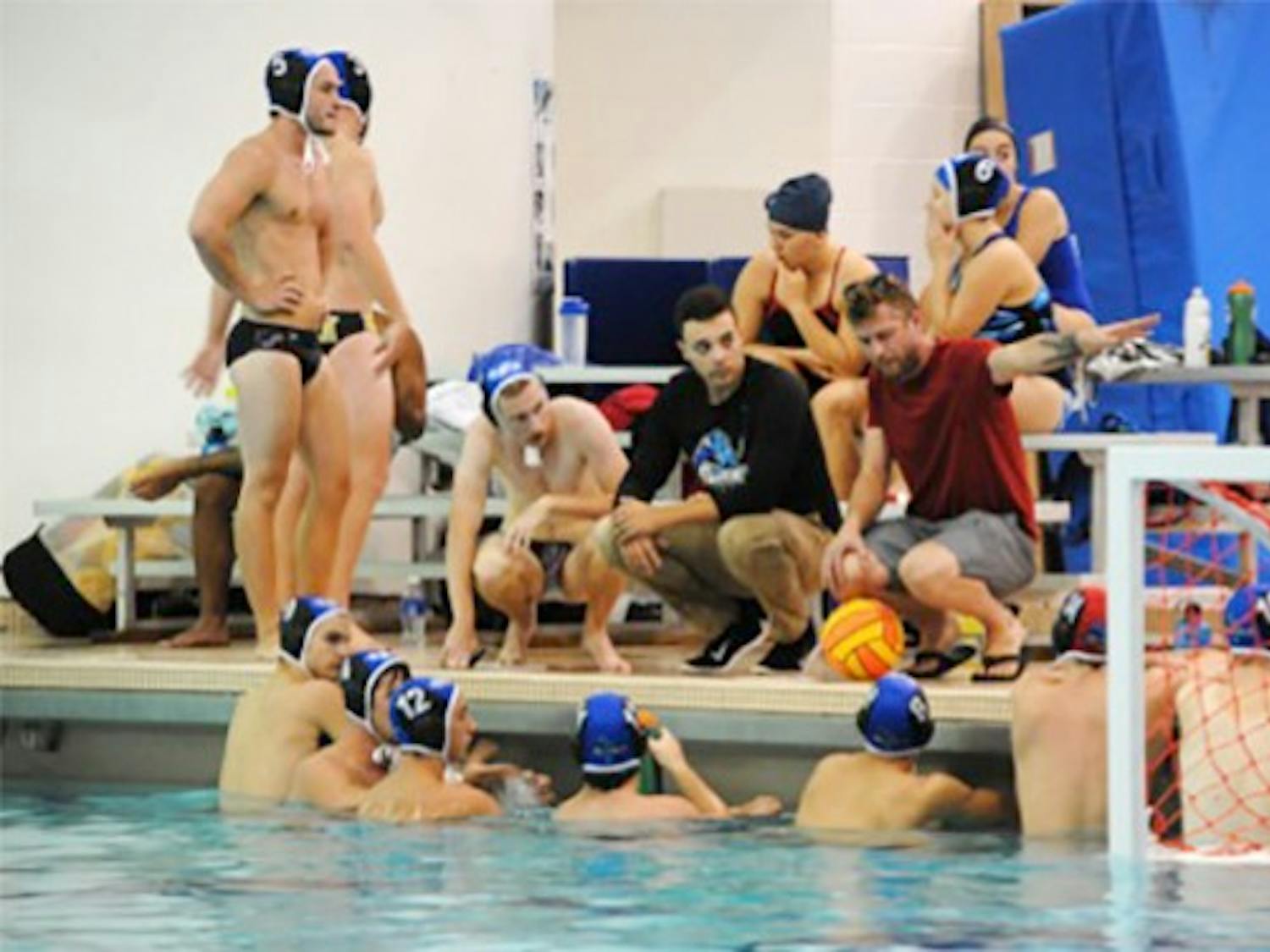 Members of the Buffalo water polo team huddle near the end of the pool in Alumni Arena. The club team is currently in its first season as a part of the Collegiate Water Polo Association.