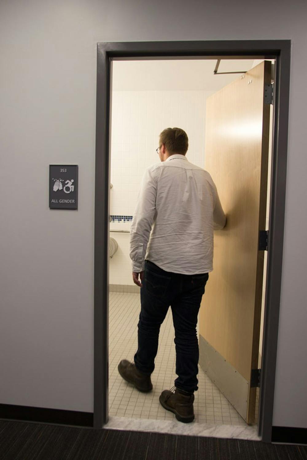 <p>A UB student walks into the new gender-neutral bathroom in the Oscar A. Silverman Library.&nbsp;UB recently introduced gender-neutral bathrooms in the library located in Capen Hall.&nbsp;</p>