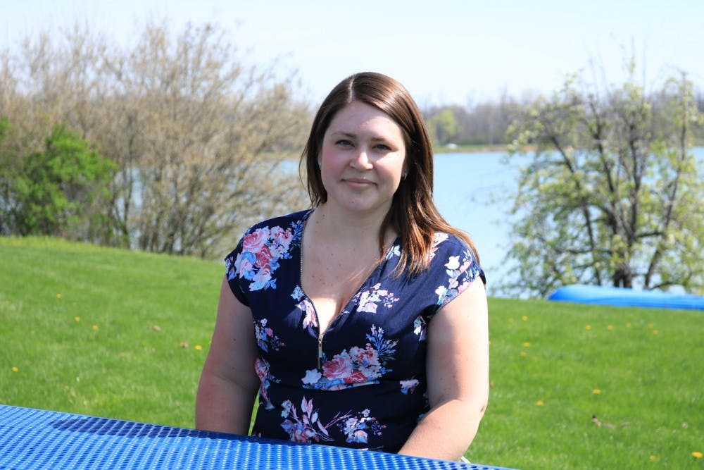 <p>Lauren Mojeski, a senior history major, sits in front of Lake LaSalle.</p>
