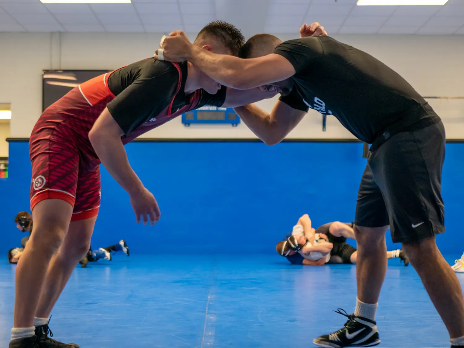 Wrestlers practice their drilling positions during warmup.