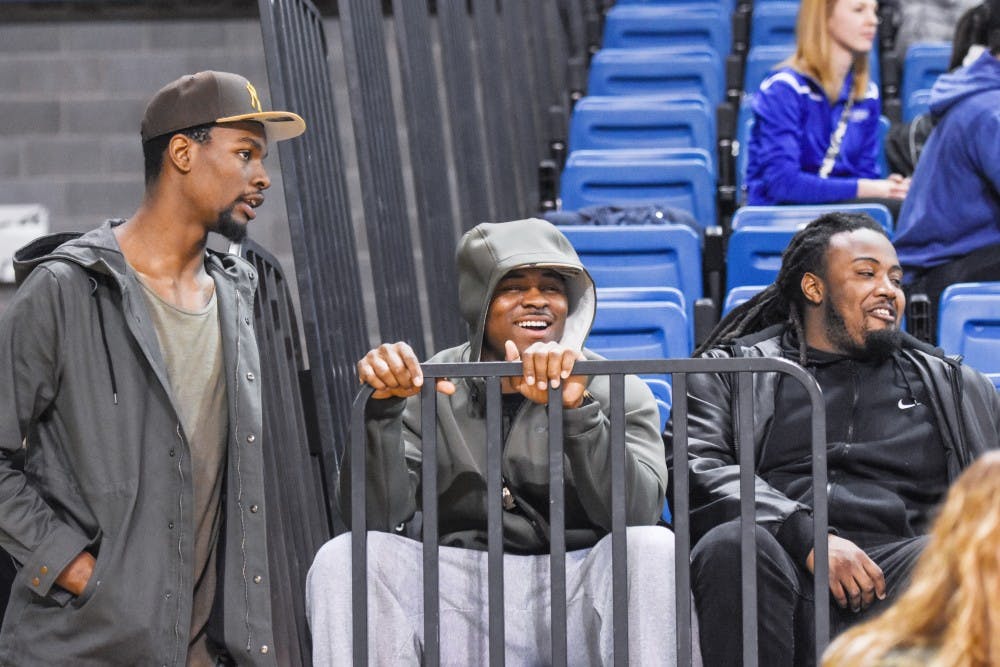 <p>Former Bulls forward Xavier Ford (far left)&nbsp;and linebacker Khalil Mack (center) take in a UB basketball game at Alumni Arena Friday night. Ford, Mack and former running back Branden Oliver have all gone on to professional careers and&nbsp;returned to campus this weekend.&nbsp;</p>