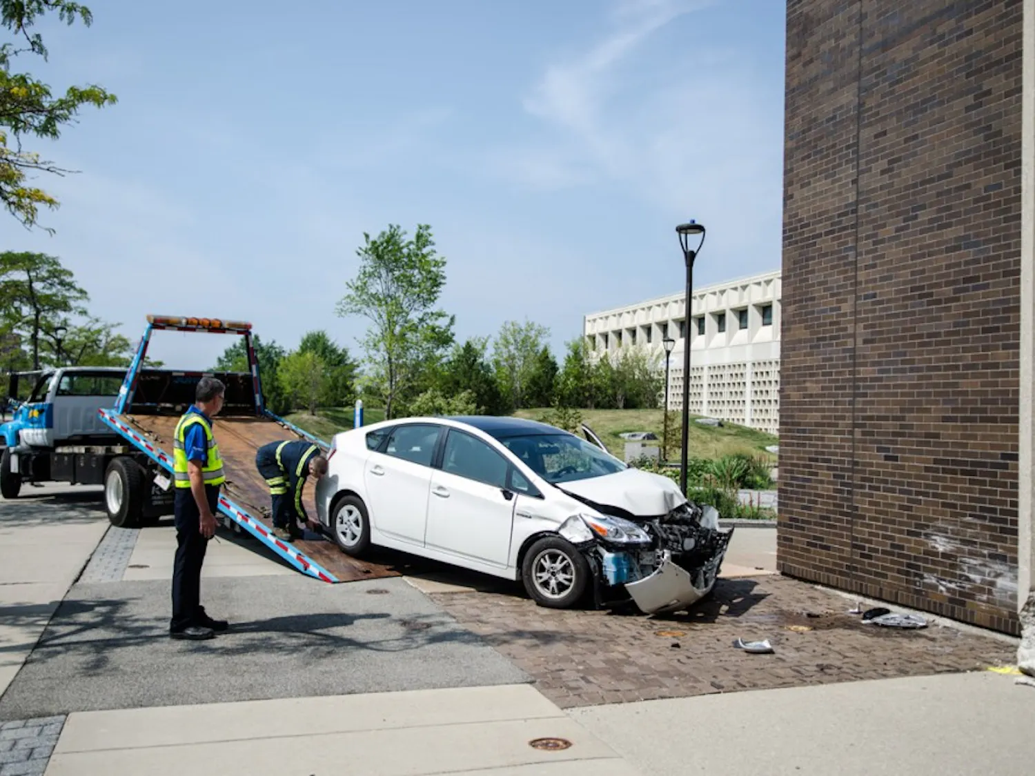 A car is towed away from Furnas Hall after it crashed into the building Tuesday.