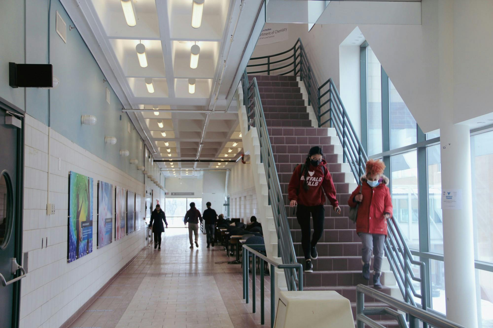 Students descend the Natural Sciences Complex stairs in masks.