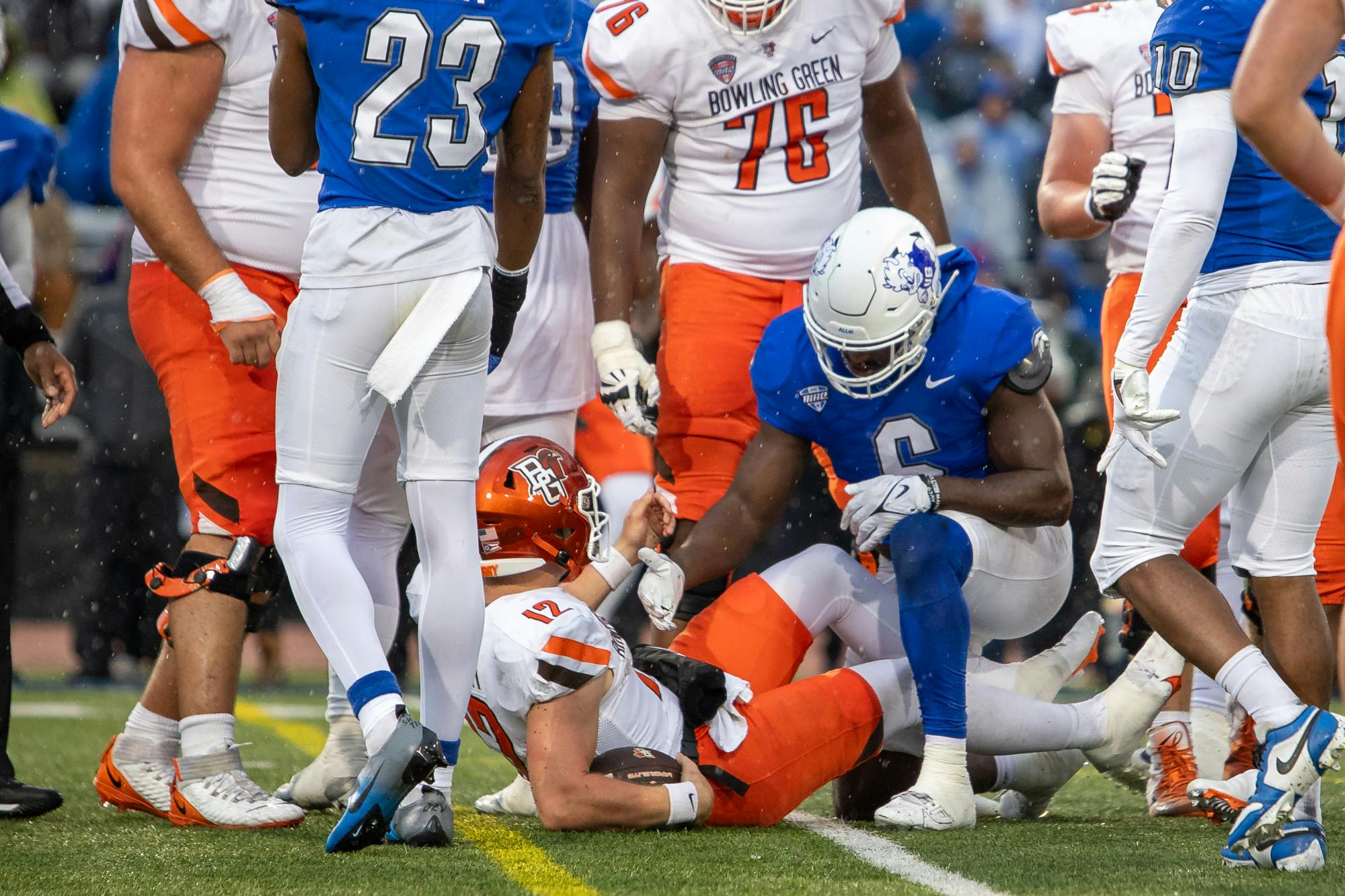 UB’s Max Michel helps up the Bowling Green quarterback after a tackle during last Saturday’s game.