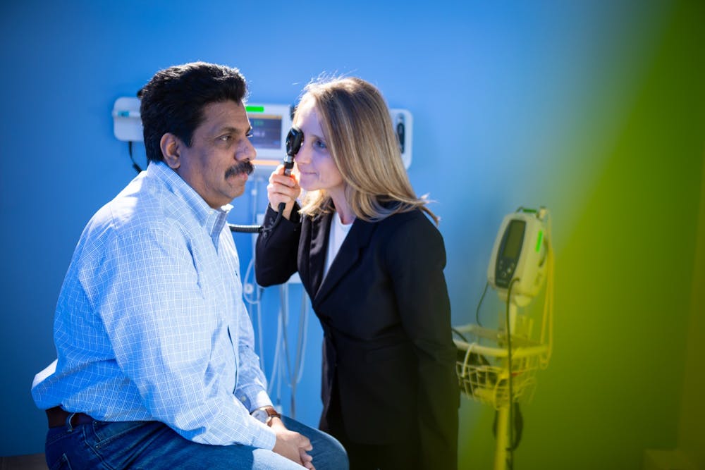 <p>Professor Kinga Szigeti examines a patient in a clinical setting.</p>