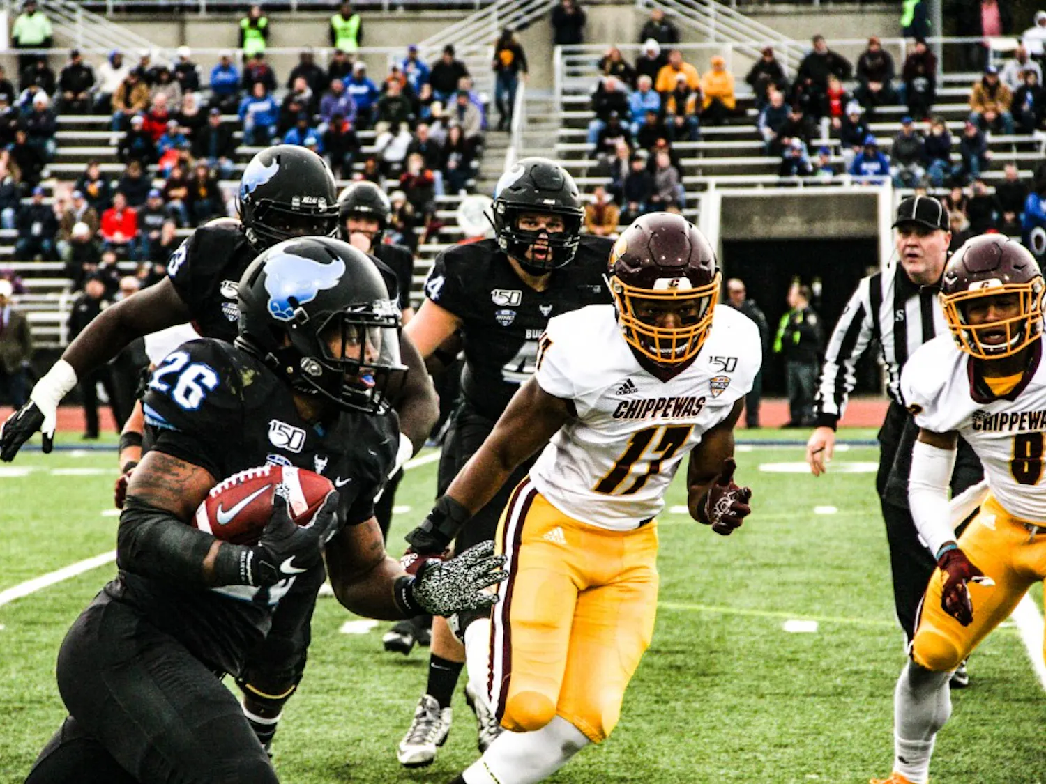 The Buffalo Bulls' running back Jaret Patterson rushes with the ball as the Central Michigan Chippewas close in.