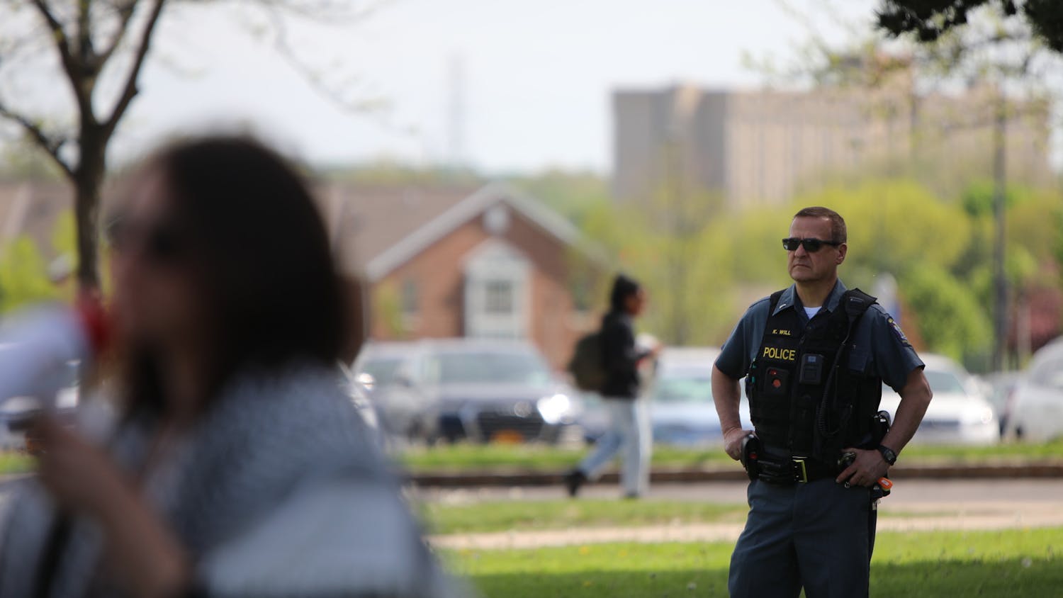 A University Police officer watches while a speaker addresses a pro-Palestinian gathering of social work students and faculty.