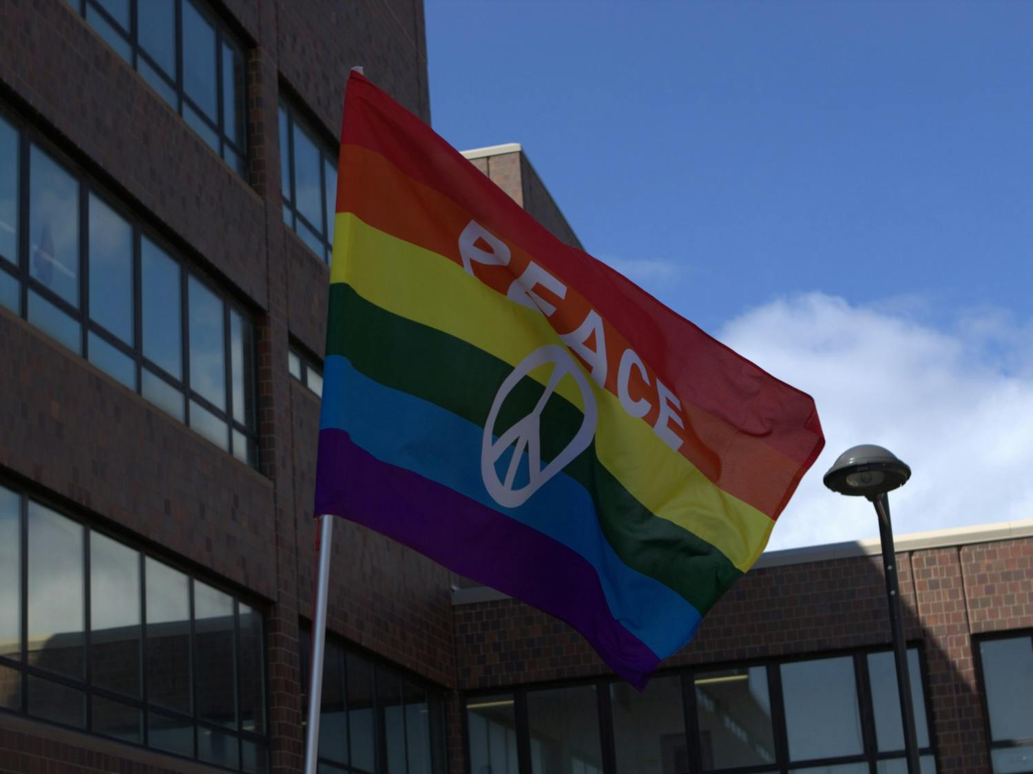 A student displays a “Peace” flag during a campus Gay Pride Parade in April 2019.