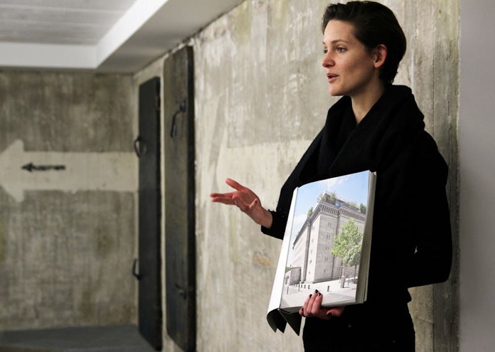 <p>Johanne Kristensen, who works at the Boros Bunker, shows off a photo to guests of what the Nazi Bunker turned art gallery looks like from the outside.</p>