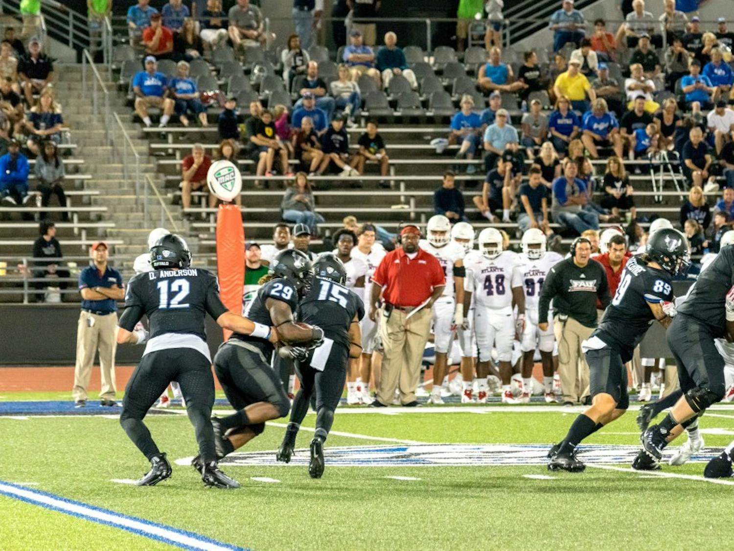 Junior quarterback Drew Anderson hands off the ball to redshirt sophomore running back Emmanuel Reed. Reed ran for 144 yards and three touchdowns Saturday.