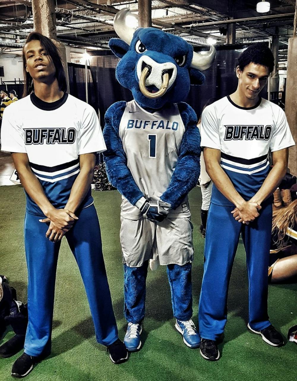 <p>Bobby Lundy (left) and Terrell Richardson pose with UB mascot Victor E. Bull. Lundy and Richardson never intended on joining the cheer team but coincidentally joined the same day</p>