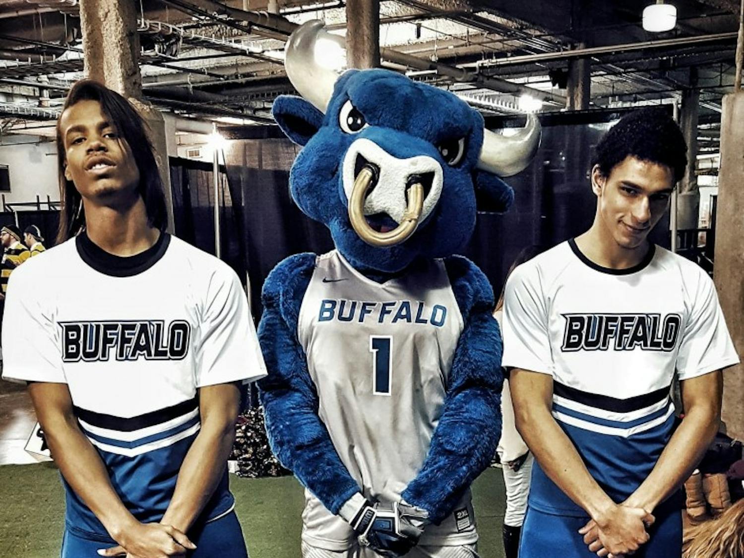 Bobby Lundy (left) and Terrell Richardson pose with UB mascot Victor E. Bull. Lundy and Richardson never intended on joining the cheer team but coincidentally joined the same day