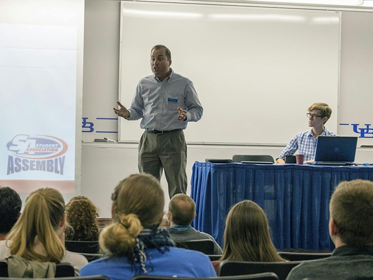 Chris Clune (middle), director of UBIT customer service, speaks during Wednesday's Student Association Assembly meeting as Speaker James Corra (far right) listens. It was SA Assembly's first meeting of the semester. 