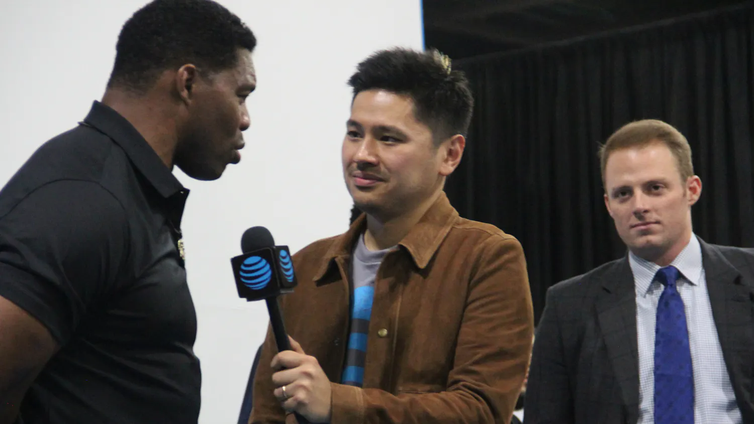 Pablo Torres (middle) interviews Herschel Walker (left) with Greg McElroy (right) in the background in 2018.