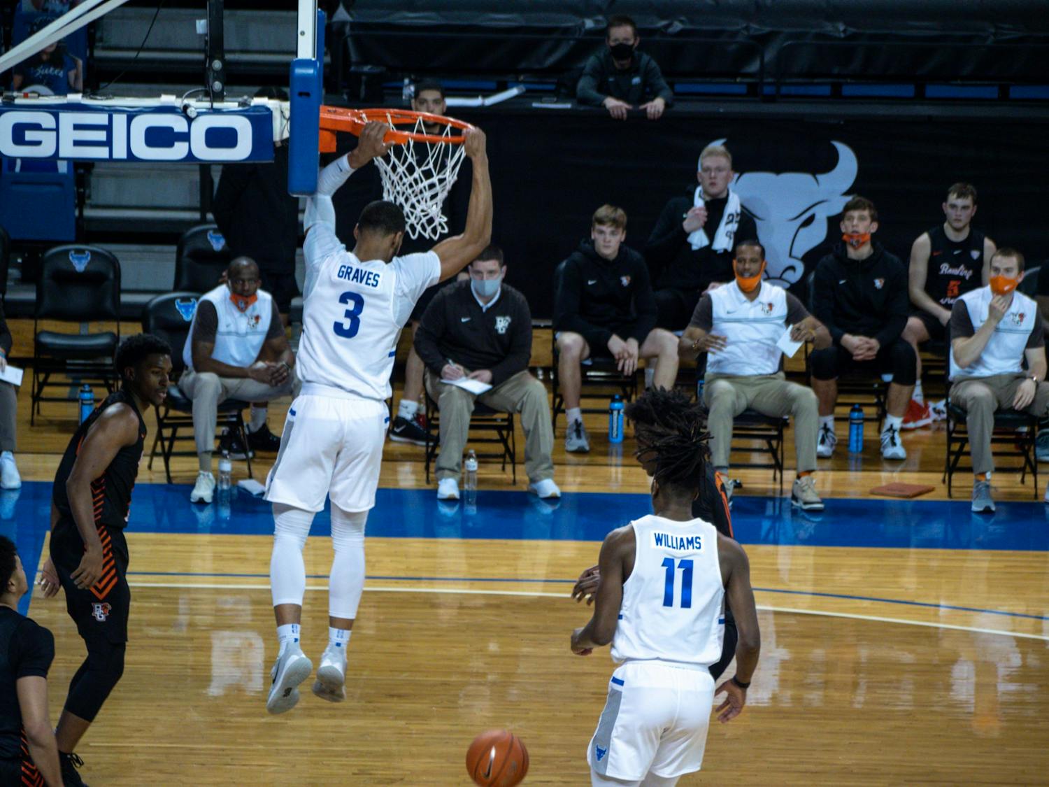Jayvon Graves hangs onto the rim after a dunk during a game last season.