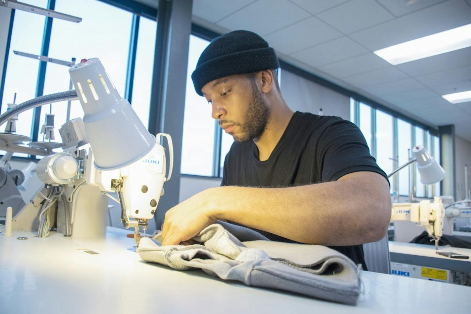 UB alumnus Rashaad Holley works on an original article of clothing. Holley recently won Best Collection at Buffalo State’s Runway 10 fashion show.