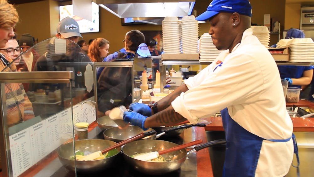 <p>Maurice Reeves, lead cook of Pistachio’s, sprinkles seasoning into a fifth pan of pasta. Lines at Pistachio’s regularly yield 30-minute wait times as people queue up to eat pasta.&nbsp;</p>