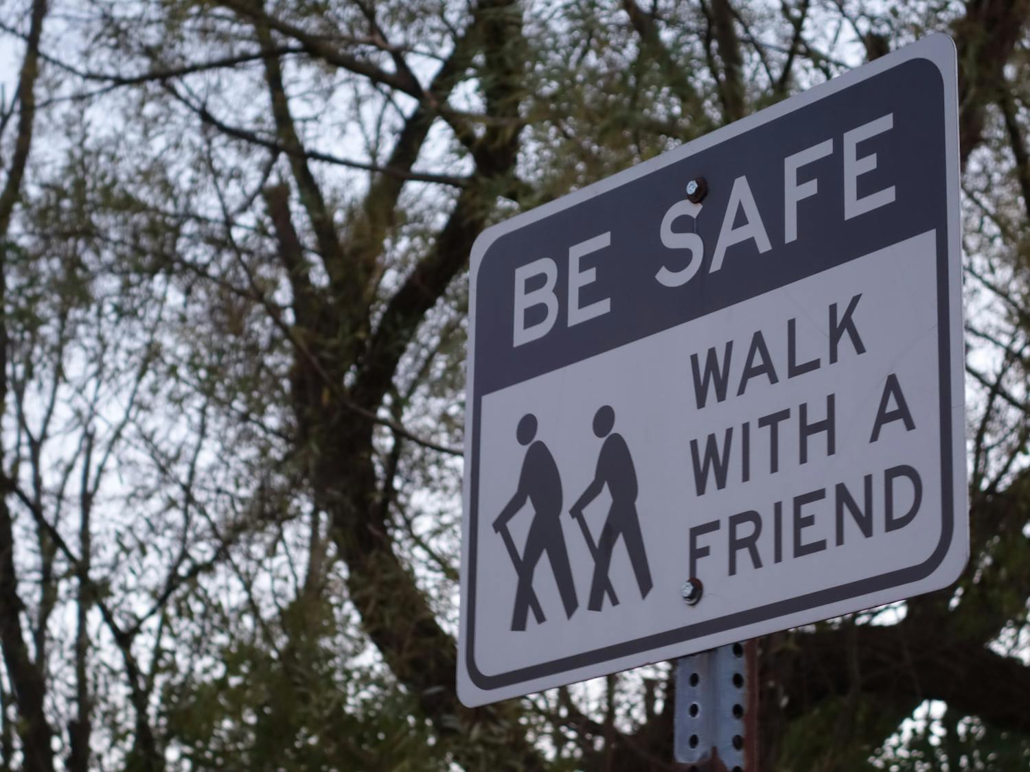 A sign advises walkers on the Ellicott creek trail to walk with a friend.
