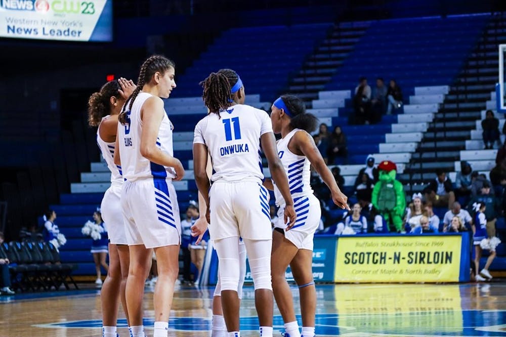 <p>UB women's basketball players huddle up near mid-court during a game last season.</p>