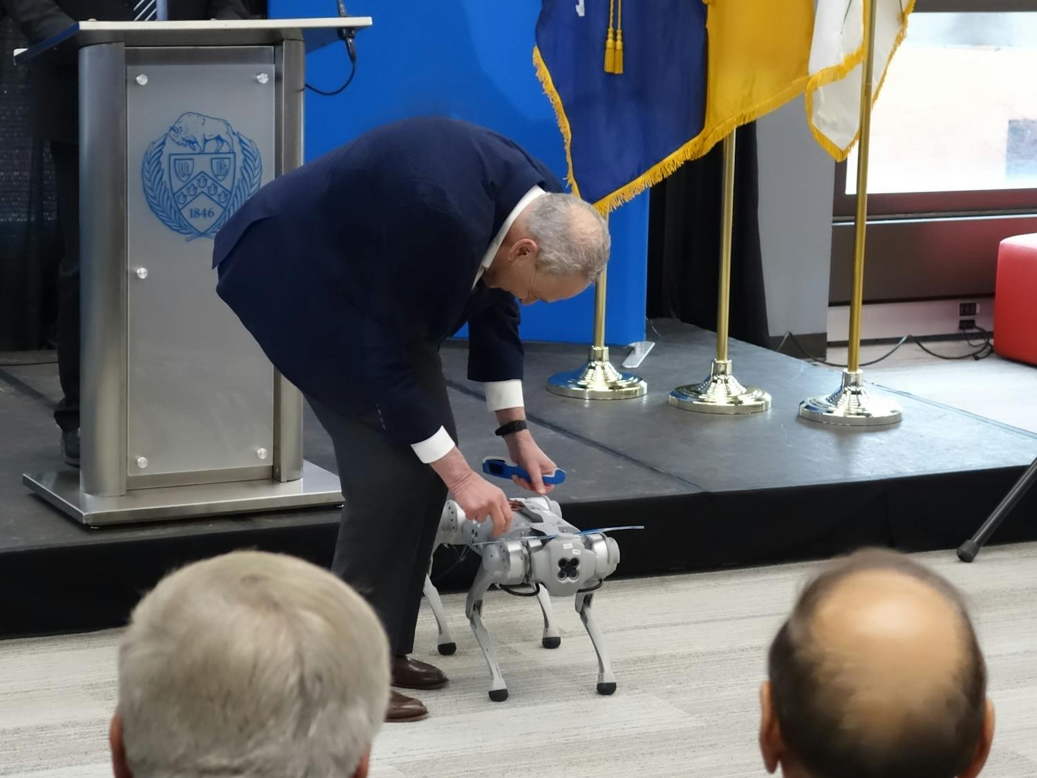 Senator Chuck Schumer put solar eclipse glasses on the "head" of UB's robot dog, "Spark."