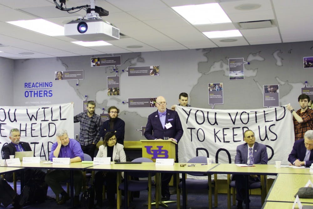 <p>Graduate students from the Living Stipend Movement hold up signs during Wednesday’s Faculty Senate Executive meeting. This was the second demonstration by LSM in two weeks.&nbsp;</p>