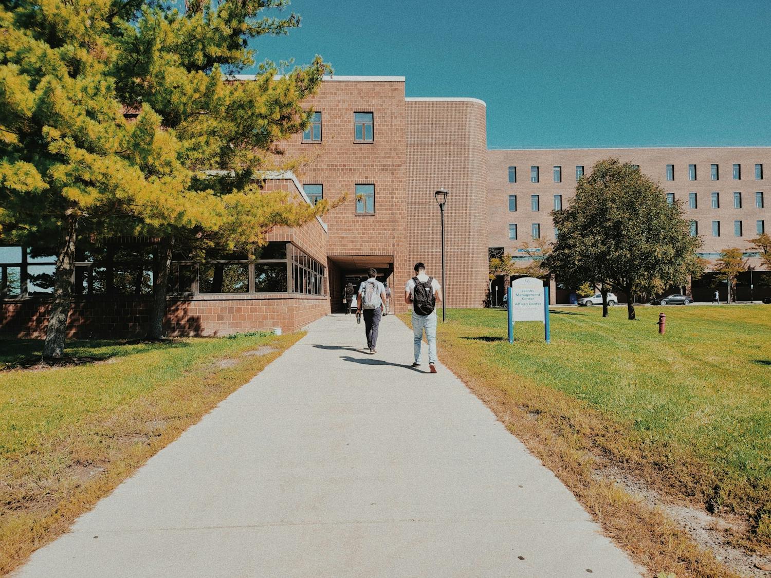 Students walk toward Alfiero Center and the Jacobs School of Management on a sunny day last semester.